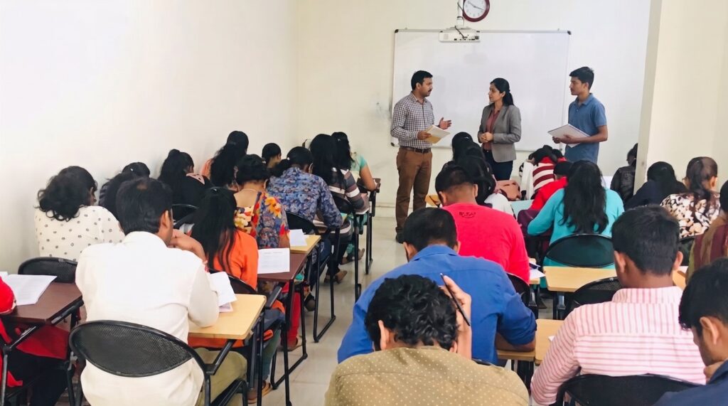 JEE foundation Class 8 students are studying while the teacher discusses with the concerned parent about JEE foundation classes.